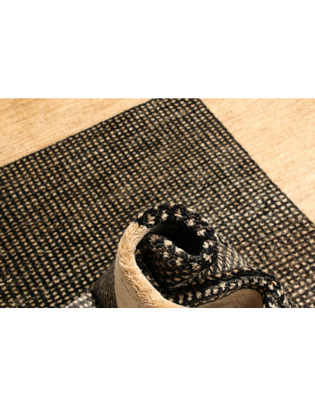 Shayan Pakistani hand-carded wool rug. Geometric black and sand design, vibrant texture. Ideal for modern and minimalist spaces.