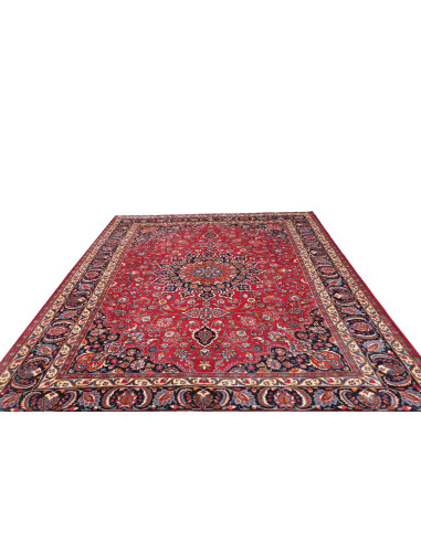 Esplora l'eleganza di questo tappeto Mashad persiano, annodato a mano in lana. Presenta un vivace campo rosso, medaglione centra