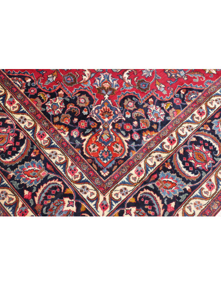 Esplora l'eleganza di questo tappeto Mashad persiano, annodato a mano in lana. Presenta un vivace campo rosso, medaglione centra
