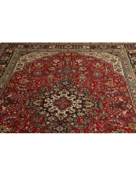 Discover the elegance of this Persian Tabriz rug. Floral medallion on a red field, blue border, and cream details. High-quality 