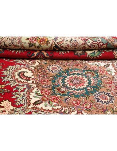 Discover the Persian Tabriz rug, a red wool masterpiece with an intricate central floral medallion. Hand-knotted with artisanal 