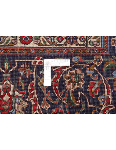 Discover the elegance of a Persian Tabriz rug. Vibrant red field, floral medallion, and dark blue borders. Crafted from hand-car