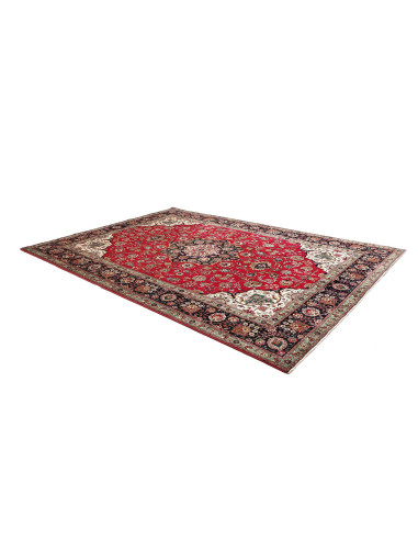 Tappeto Tabriz persiano classico. Campo rosso, medaglione centrale e bordura blu scuro con motivi floreali. Lana cardata a mano 