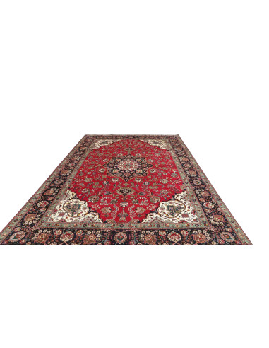 Tappeto Tabriz persiano classico. Campo rosso, medaglione centrale e bordura blu scuro con motivi floreali. Lana cardata a mano 