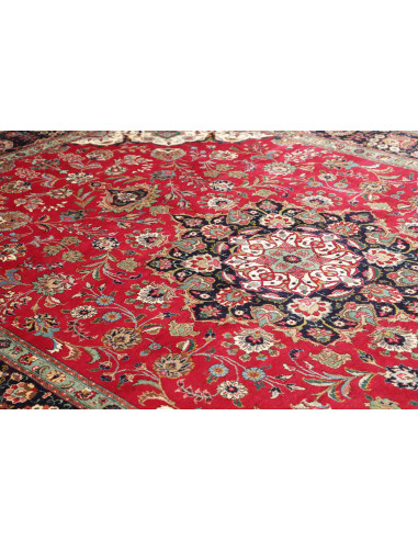 Tappeto Tabriz persiano classico. Campo rosso, medaglione centrale e bordura blu scuro con motivi floreali. Lana cardata a mano 