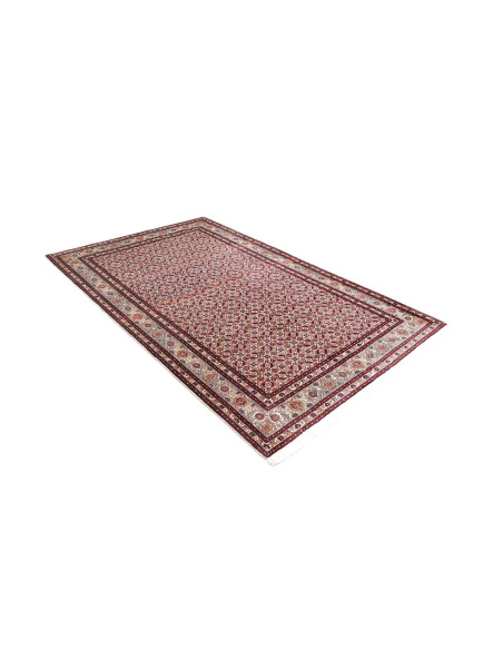 Discover the Persian Moud rug, hand-knotted with quality wool. Features an all-over red, cream, and blue pattern, perfect for cl